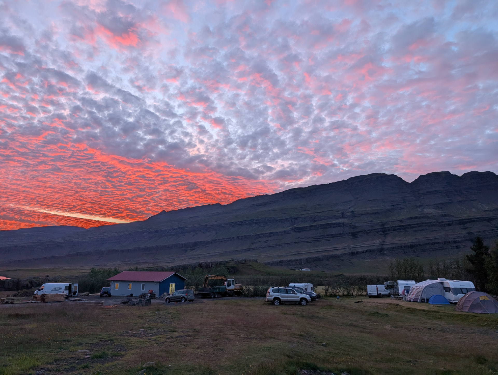 Tjaldsvæðið í kvöldsól undir fjöllum